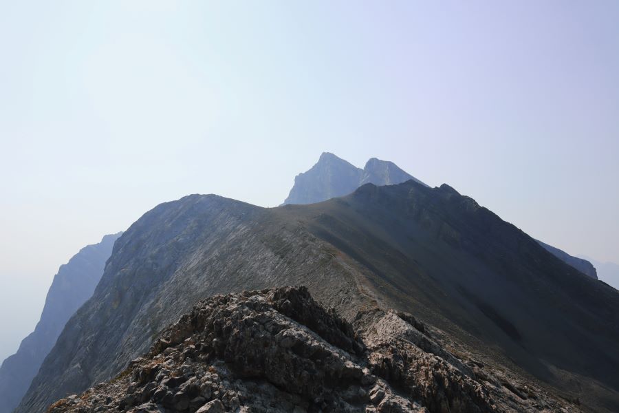 view of a hazy Miner's Peak from the ridge of the saddle of Ha Ling Peak