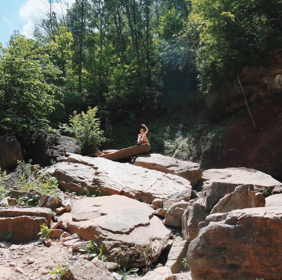 sitting on boulders in a riverbed in Ontario, Canada
