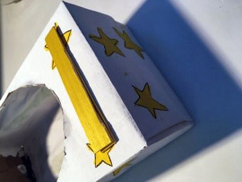 Attach the popsicle sticks to the box.